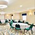 Holiday Inn & Suites Regina meeting room with round banquet tables and green chairs