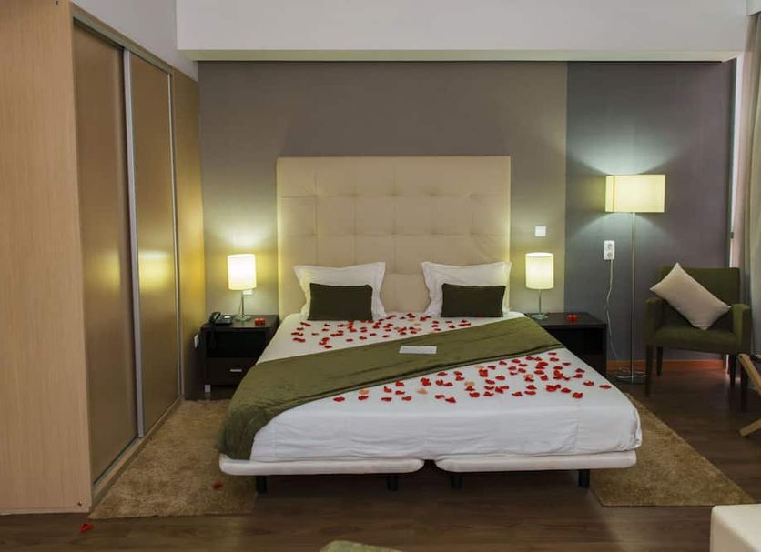 Hotel Santiago, Praia: modern guest room with king bed, bedside lamps, wardrobe and chair