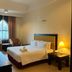Puteri Bay Hotel in Malacca guest room with queen bed, armchairs, desk and tall window