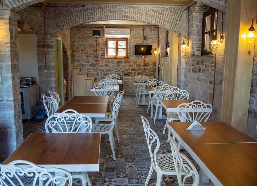 Olea Leya Hotel in Ayvalik dining room with wooden tables and white wrought-iron chairs