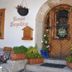Pension Leopoldine in Hallstatt: stone-arched wooden entrance with flowers and hanging planter