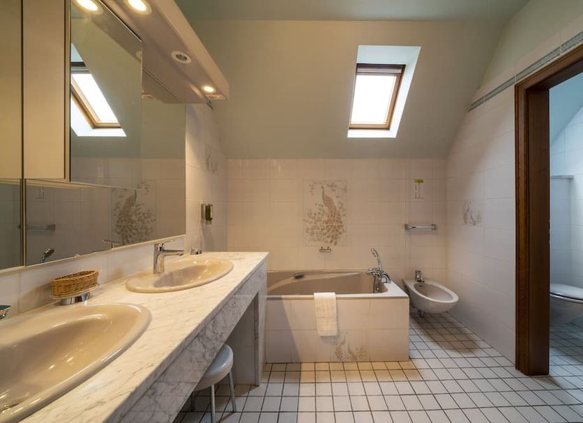 Hotel Munsch in Saint-Hippolyte bathroom with double sink, bathtub, bidet and skylights
