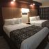 Seahorse Inn in Wildwood guest room with two double beds, wall lamp, desk, and blue door