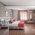 Faial Prime Suítes Florianopolis room with two beds, desk, TV and window curtains