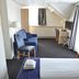 Fletcher Badhotel Egmond aan Zee room with twin beds, sofa, desk and TV in Egmond aan Zee