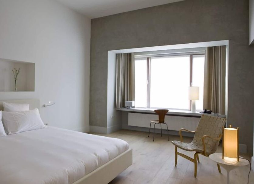 Hotel Wu Wei in Kortrijk: minimalist guest room with bed, desk, chair and large window nook