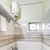 Hotel Golden Treat, Indore: compact bathroom with wall-mounted water heater, shower and small window
