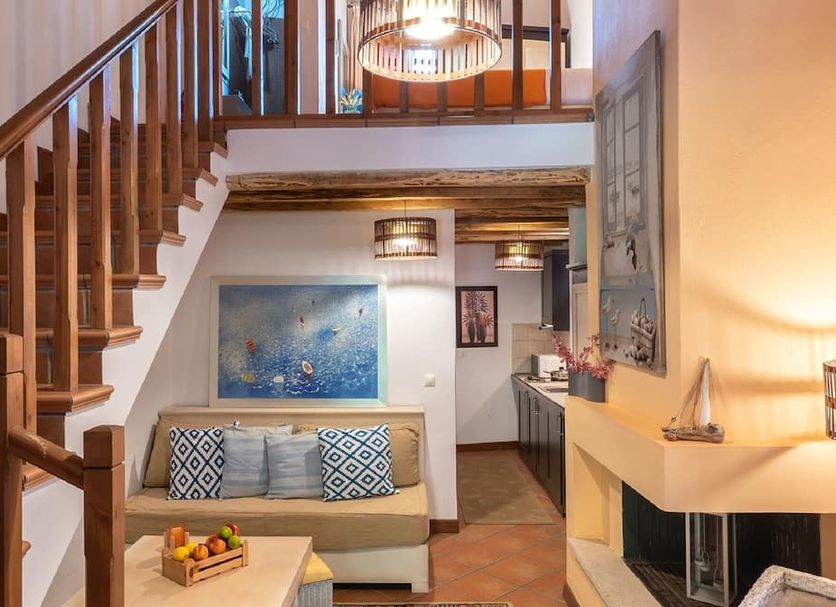 The Varos Residences Hotel in Város: loft-style suite with staircase, sofa, and fireplace