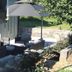 Outdoor patio seating at Glenn Meadow Bed and Breakfast in South Haven with umbrella and stone wall