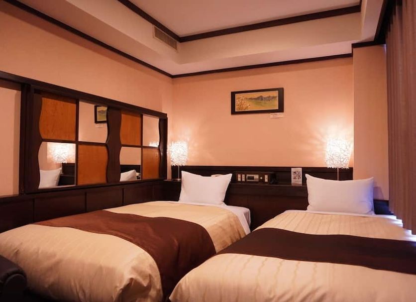 Hotel New Station, Matsumoto guest room with two twin beds and warm lighting
