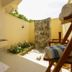 Hondaafushi Island Resort in Hanimaadhoo: open-air bathroom with stone shower, sink, and sunlit lounge chairs