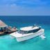 OZEN Reserve Bolifushi in Bolifushi with a luxury yacht beside a pier and thatched overwater pavilion