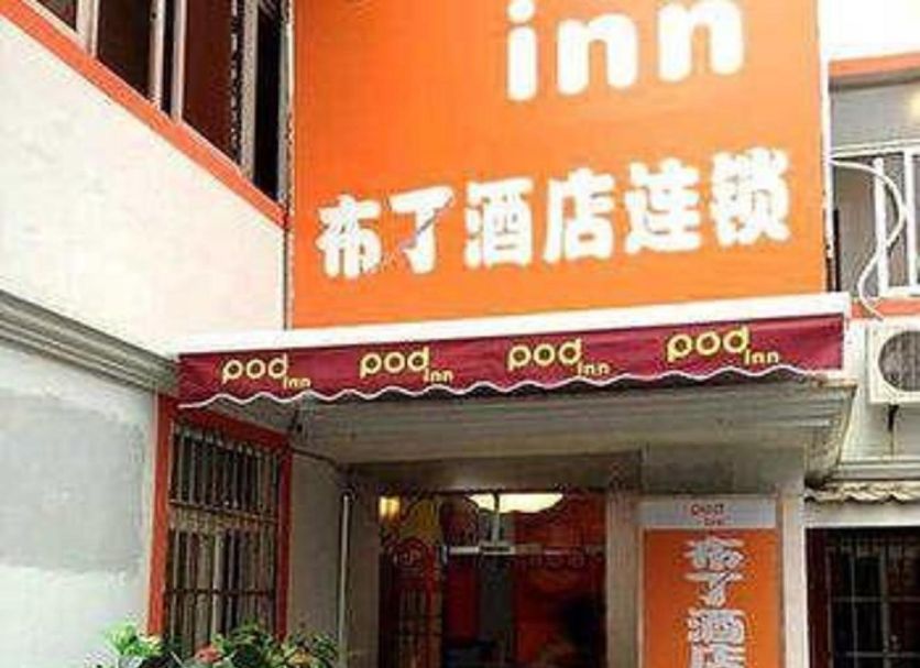 Pod Inn Shanghai Lujiazui entrance with orange signage and potted plants in Shanghai