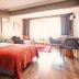 Taks-Inn Suites Istanbul bedroom with bed, seating area, desk and large window with curtains