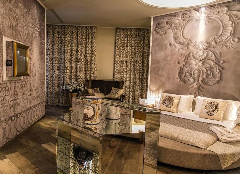 Hotel Villa Pascucci in Durrës with ornate suite, glass table, patterned curtains and curved seating