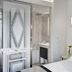 La Villa Haussmann Paris guest room with marble bathroom, white bed, and blue wall art