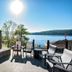 The Lodges at Cresthaven in Lake George: lakeside patio with stone fireplace and Adirondack chairs