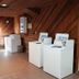 Denison Inn & Suites in Denison laundry room with two washers, dryer, and wood-paneled walls