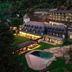 Andorra Park Hotel in Andorra la Vella with illuminated terraces, landscaped grounds, and a pool at dusk