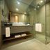 Berjaya Makati Hotel bathroom with glass shower, vanity, and toilet in Makati