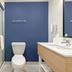 Spark by Hilton Harrisonburg University Area bathroom with glass shower, toilet, vanity and blue accent wall
