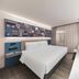 ibis Beijing Dacheng Road room with bed, sofa, wall mural, and large TV in Beijing