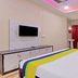 Hilltown Hotel Madikeri guest room with double bed, wall TV, vanity, and red curtains