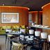 Memmo Principe Real Lisbon lounge with green sofas, black tables, and warm wood-paneled curved walls