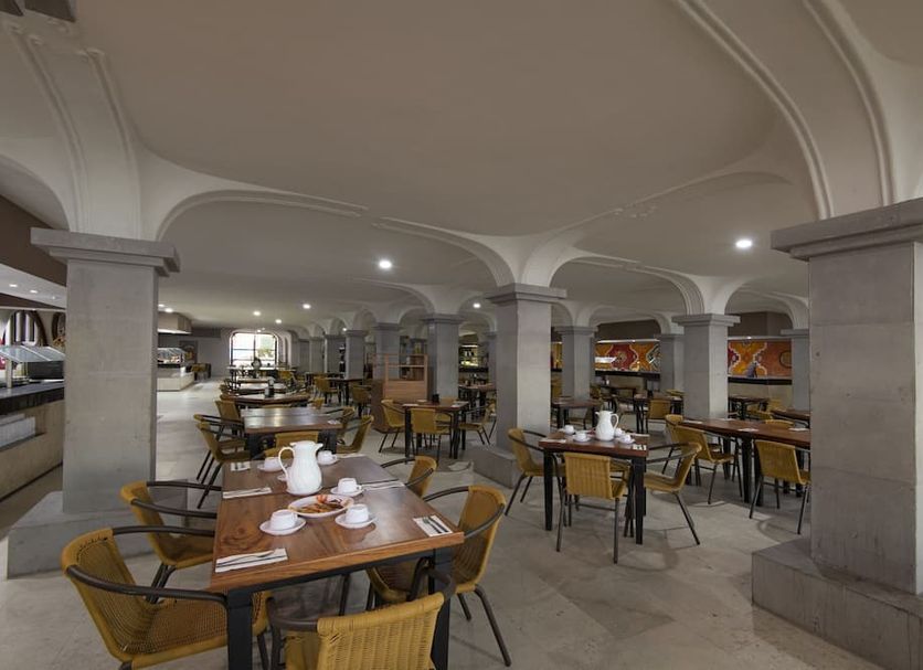 Club Fiesta Mexicana Beach in Manzanillo restaurant with tables and chairs under arched columns