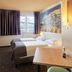 B&B Hotel Frankfurt City-Ost room with twin beds, wall art, desk and city view in Frankfurt am Main