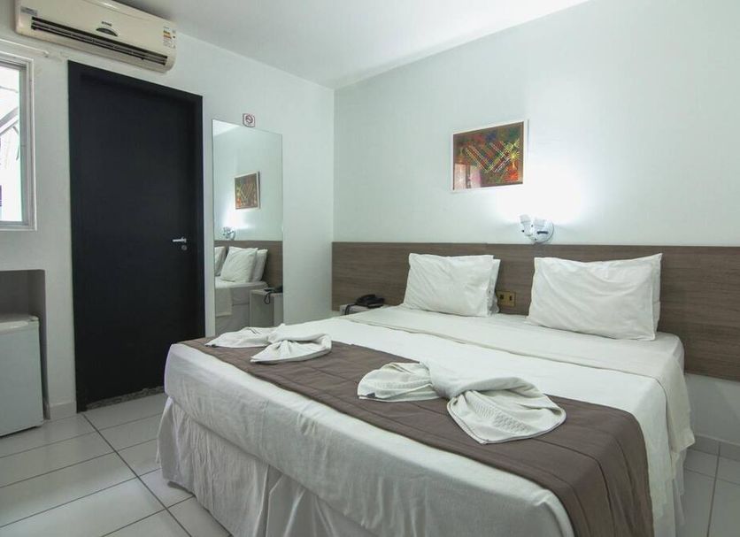 Tropico Praia Hotel in Maceió guest room with double bed, wall mirror and air conditioner