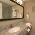 Bathroom at Medicine Hat Suites in Medicine Hat with granite vanity, mirror, toilet, and glass shower