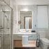 Oakwood Residence Saigon bathroom in Ho Chi Minh City with glass shower, vanity, toilet and bathtub
