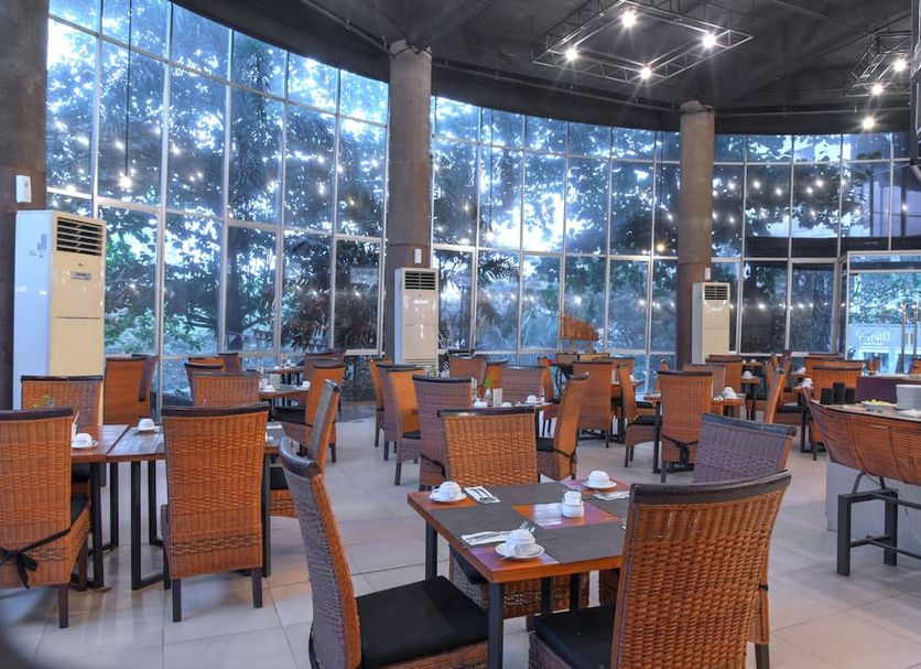 Oak Tree Emerald Hotel & Conventions Semarang dining area with large windows overlooking trees