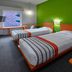 City Express Junior by Marriott Guadalajara Periférico Sur room with two twin beds and bright green accent wall