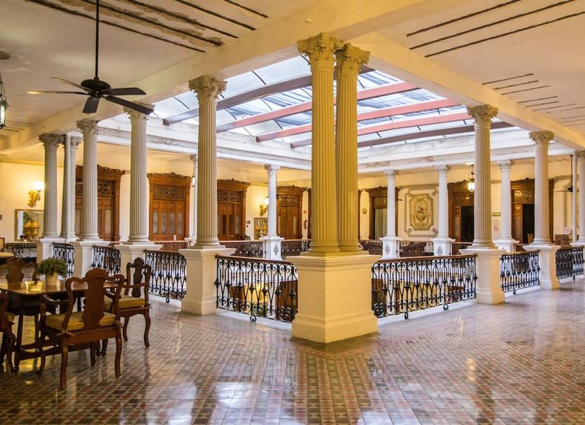 El Gran Hotel in Mérida interior atrium with ornate columns, tiled floor and balcony railings