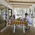 Vela Blu Camping Village in Cavallino Treporti: family dining on a covered wooden terrace among trees