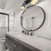 Hotel Cabana Clearwater Beach bathroom with marble vanity, round mirror, and glass walk-in shower
