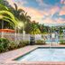 Mizner Place at Weston Town Center pool area with palm trees and sunset sky in Weston