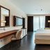 Delta Hotels by Marriott Olbia Sardinia guest room with king bed, desk, and balcony doors in Olbia
