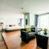 Raha Grand Hotel Patong room with sofa, dining table, bed, and floor-to-ceiling windows