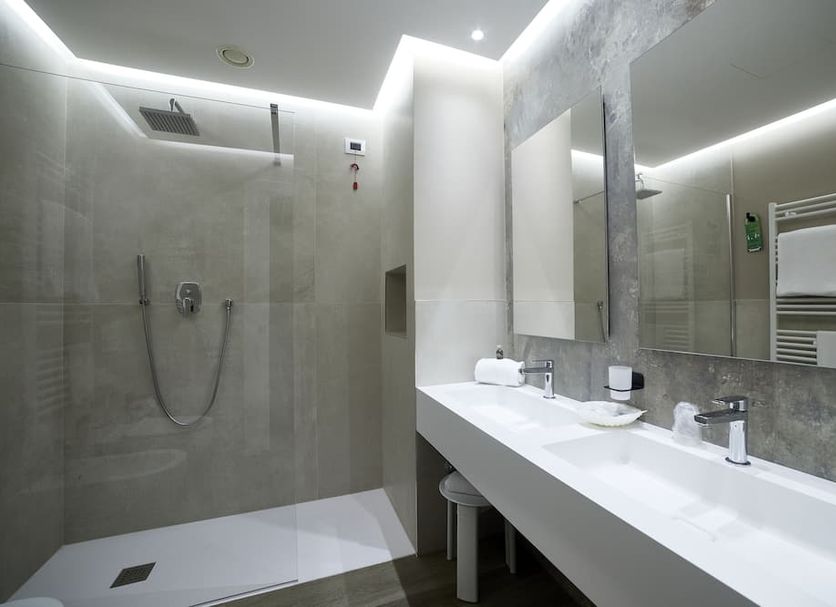 La Perla, Camerano: modern bathroom with walk-in shower, double sink vanity, and large mirror