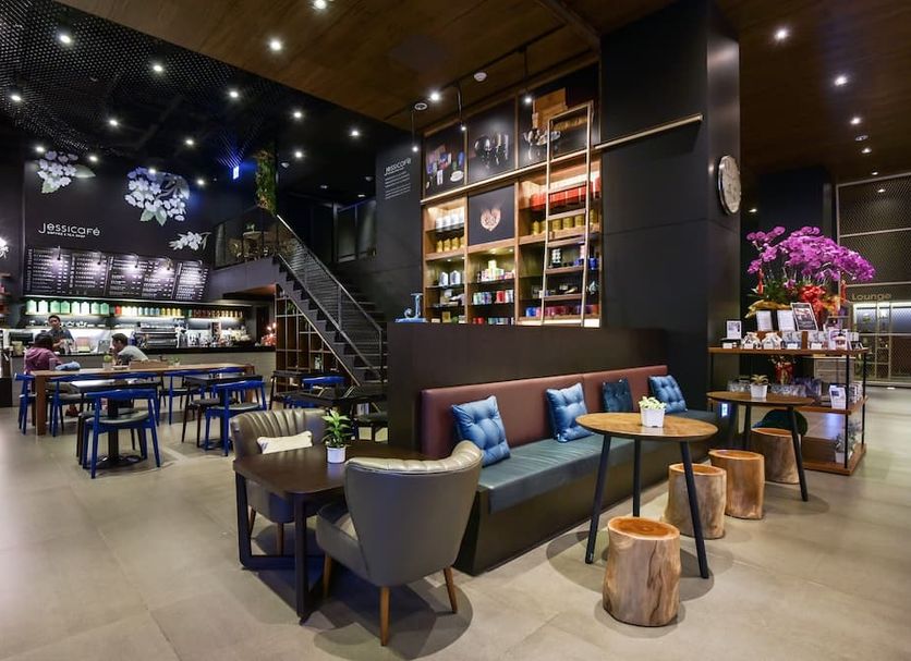 Just Sleep Kaohsiung Station lobby lounge with bar, staircase, seating area and shelves in Kaohsiung City