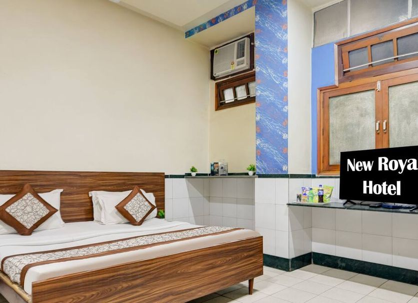 New Royal Hotel in New Delhi guest room with bed, desk, wall AC and window