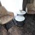 Rina Vista in Brașov guest seating area with two beige chairs and round marble tables by a window
