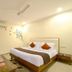 Hotel Golden Inn Chandigarh guest room with king bed, side tables, ceiling fan and wall art