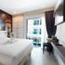 The Aim Patong Hotel guest room with king bed, balcony, wall art and TV in Patong