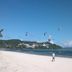 Lazy Dog Bed & Breakfast in Boracay with white sandy beach, palm trees, and kitesurfers over the sea