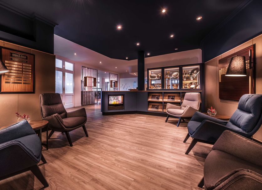 Lounge area at Steigenberger Hotel Treudelberg in Hamburg with armchairs, wood floors and bar seating