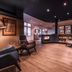 Lounge area at Steigenberger Hotel Treudelberg in Hamburg with armchairs, wood floors and bar seating